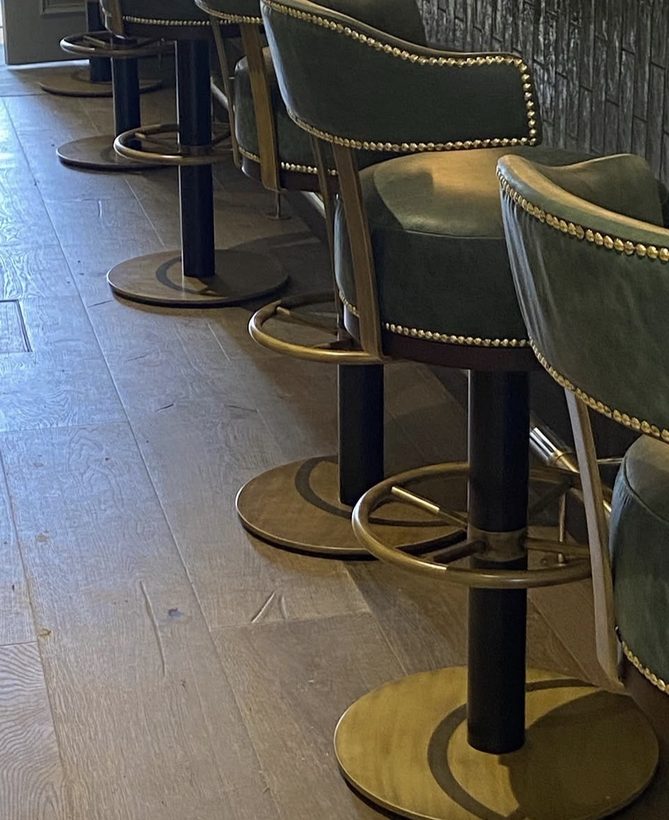 No. 23 — green leather bar stools with brass studs and swivel bases