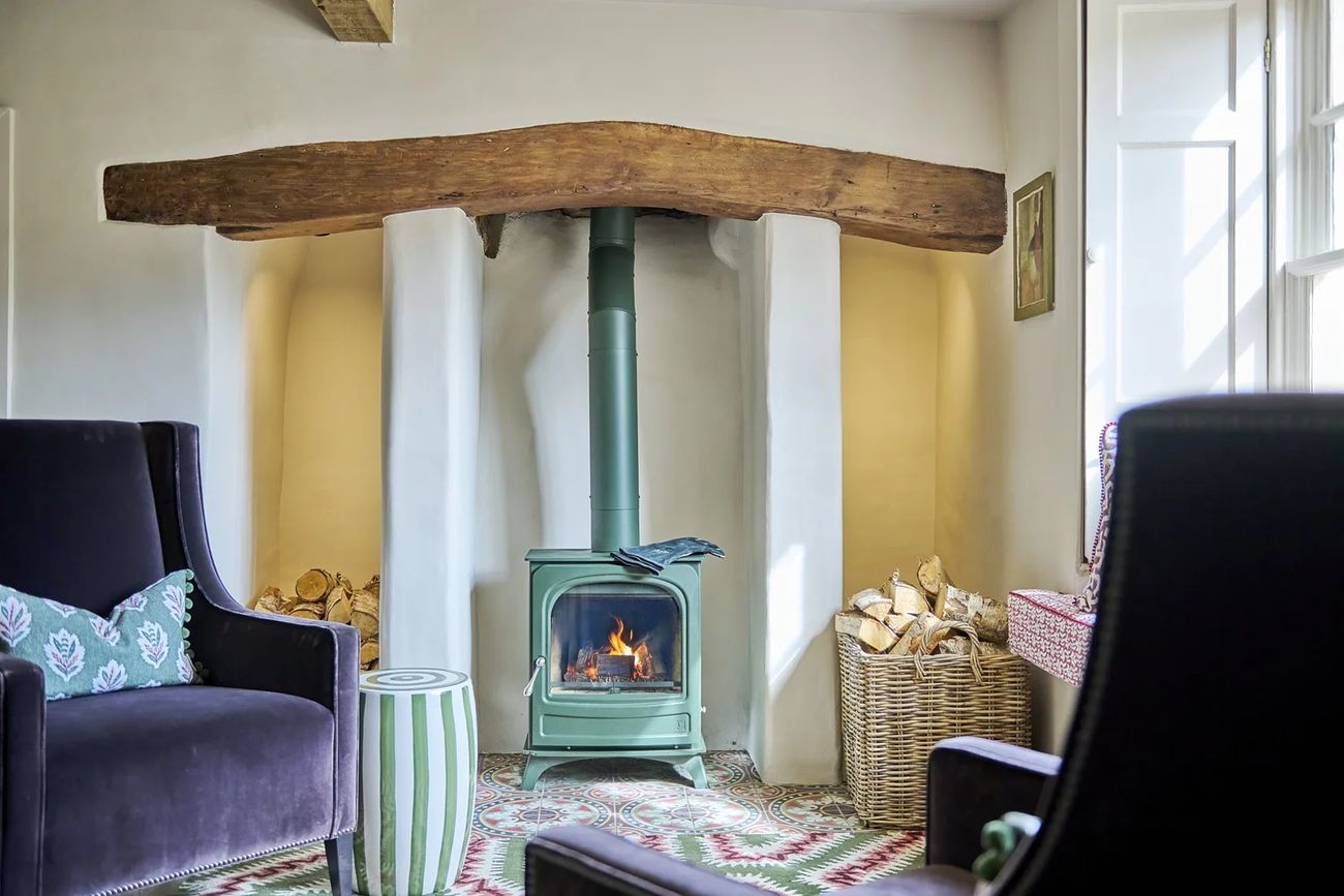 The Shambles — wood-burner in a beamed inglenook with encaustic tiles