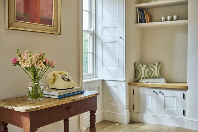 The Shambles — painted side table with cream rotary telephone and garden flowers